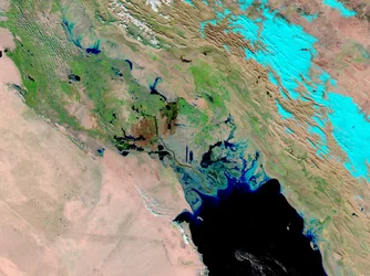 Winterregens en mogelijk smeltende sneeuw van de Zagros-gebergte in Iran vullen de moerassen en ondiepe meren van Zuid- en Oost-Irak. Lichtblauw is de met sneeuw bedekte bergen in Iran.